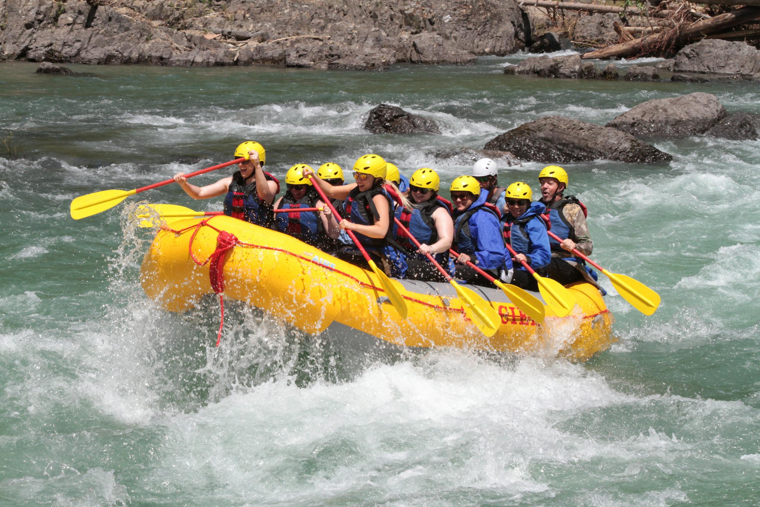 Exciting whitewater rafting team navigating rapids, showcasing teamwork and adrenaline-filled action.