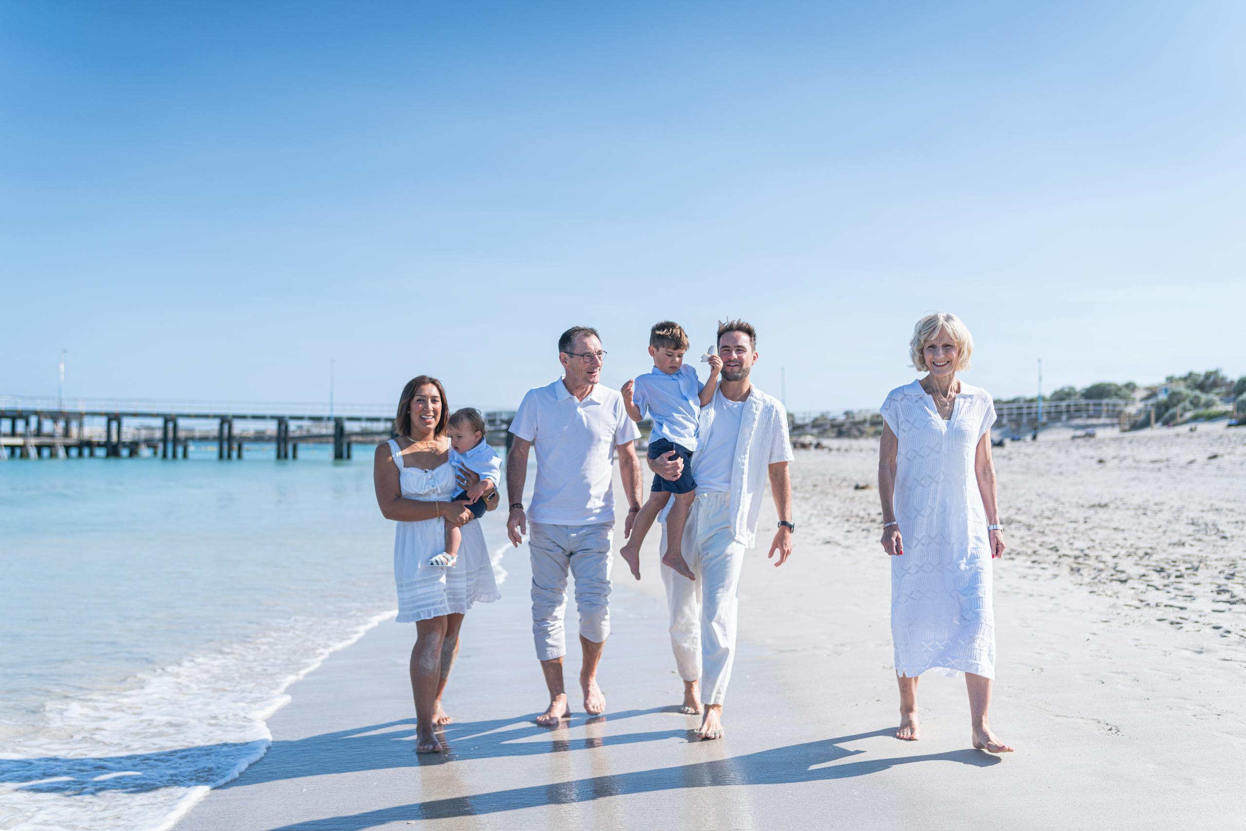 Happy multi-generational family enjoying a beach day together under the summer sun.