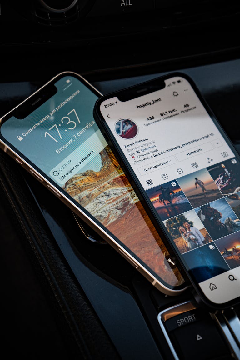 Close-up of two smartphones showing social media and lock screen in a car setting.